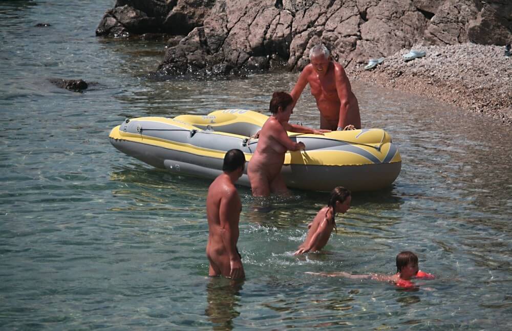 Lone Nudist in Yellow Boat photos - Nudists live together in nature and in groups