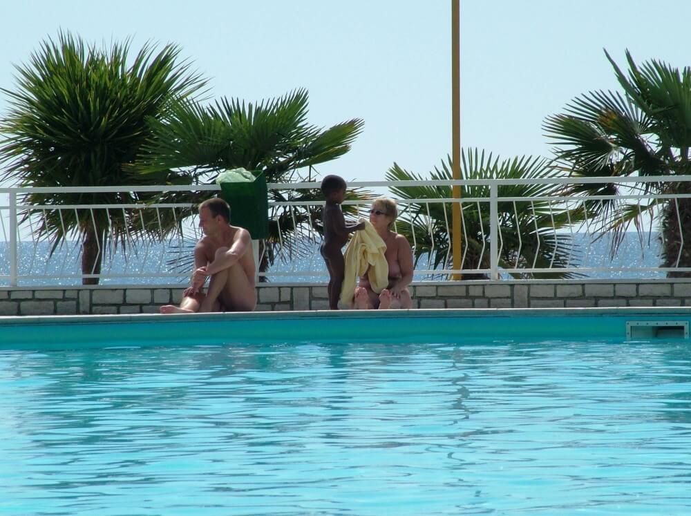 Photo of naturists in an outdoor pool - Naturism teaches us to accept everyones differences and unique qualities without embarrassment